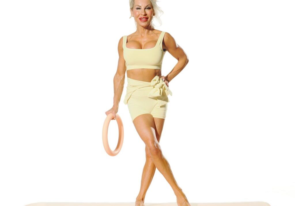Fit woman in yellow activewear holding ring.